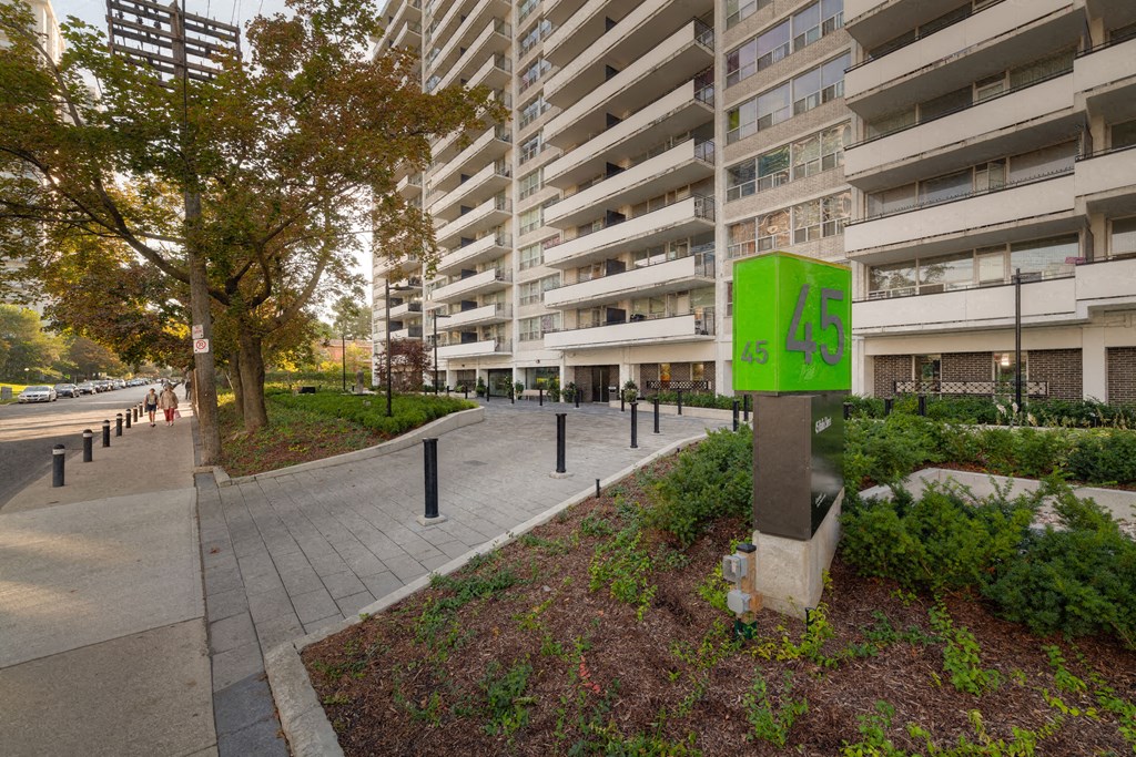 a city street with an apartment building and a sidewalk