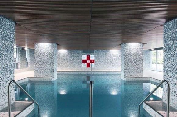 a swimming pool with a red cross on the wall