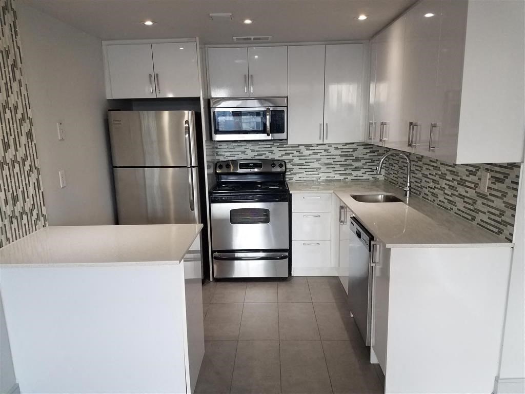 a kitchen with stainless steel appliances and white cabinets
