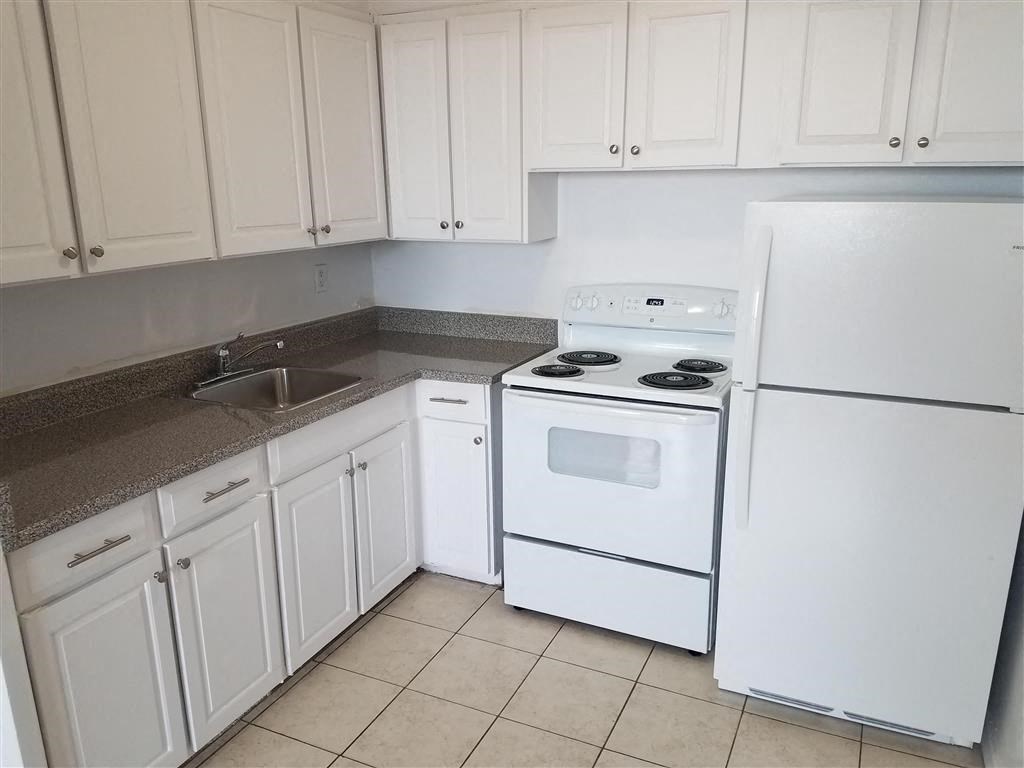 a kitchen with white appliances and white cabinets