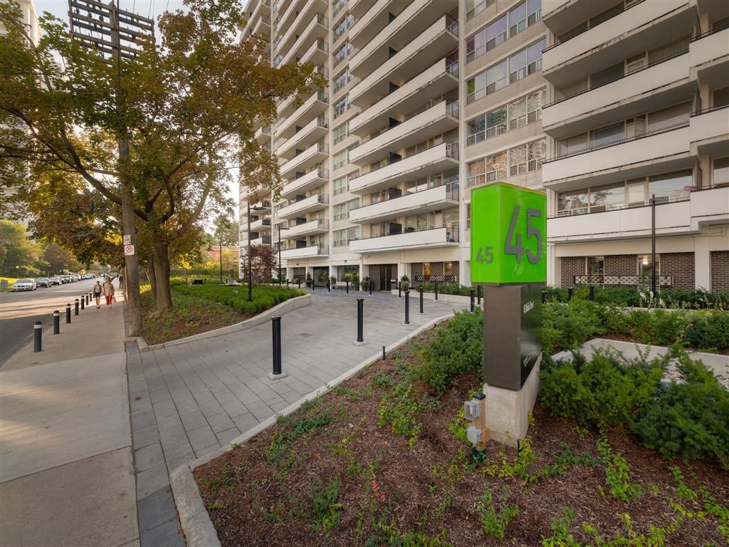 an empty sidewalk in front of an apartment building