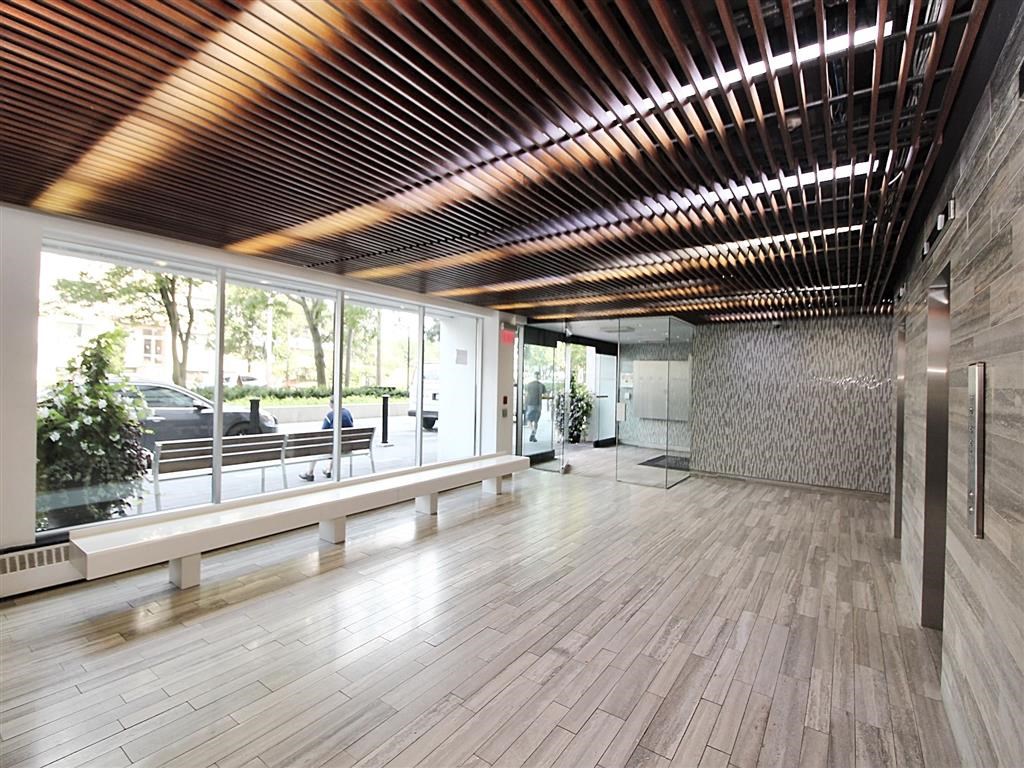 the lobby of the building has a large glass window and a bench