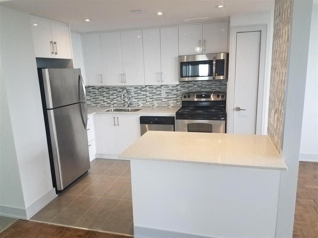 a kitchen with white cabinets and a stainless steel refrigerator
