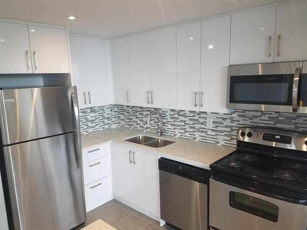 a kitchen with stainless steel appliances and white cabinets