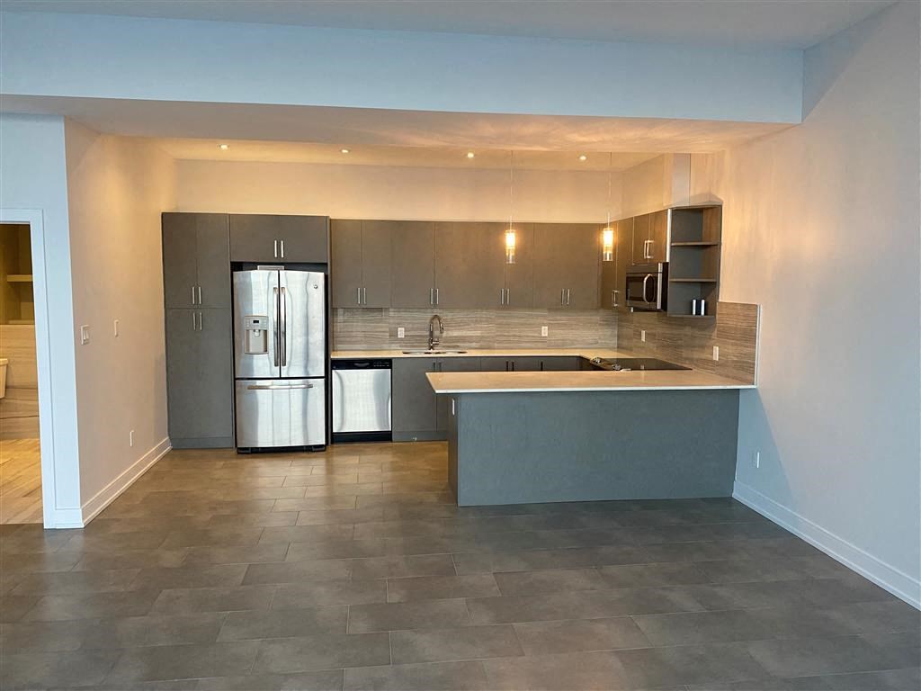 an empty kitchen with a stainless steel refrigerator