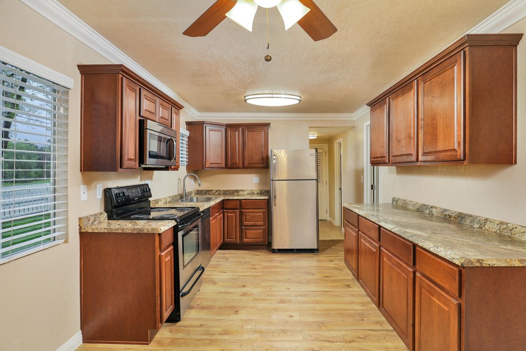 a kitchen with wooden cabinets and stainless steel appliances