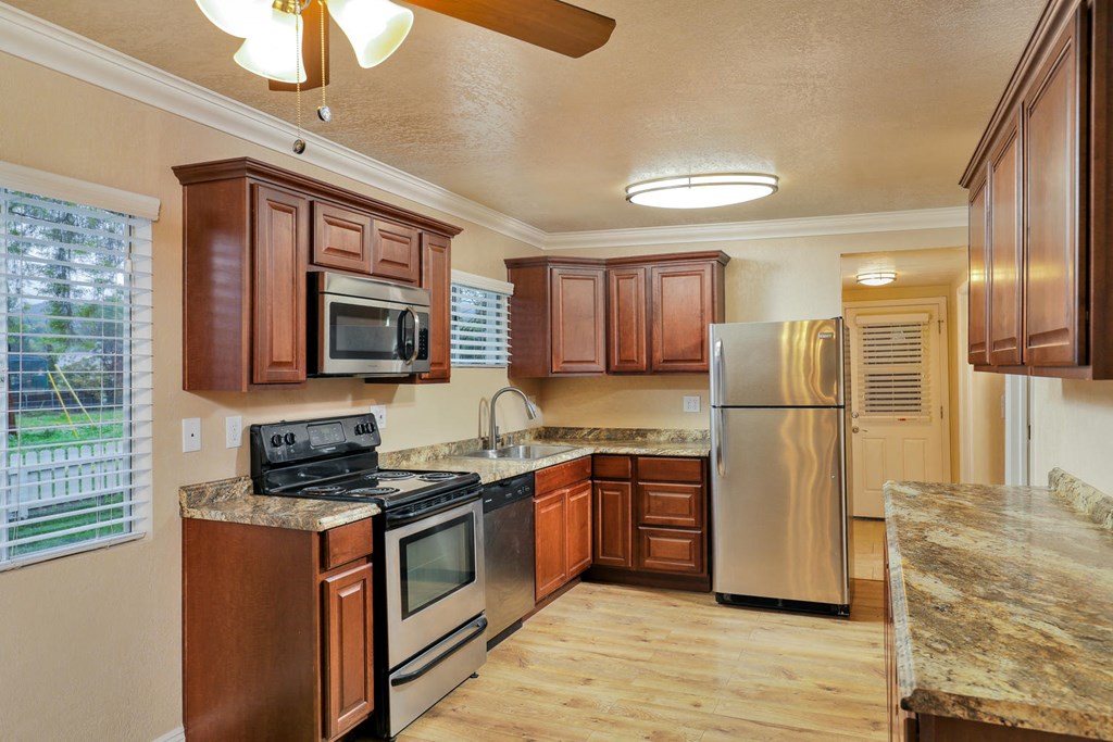 a kitchen with wooden cabinets and stainless steel appliances