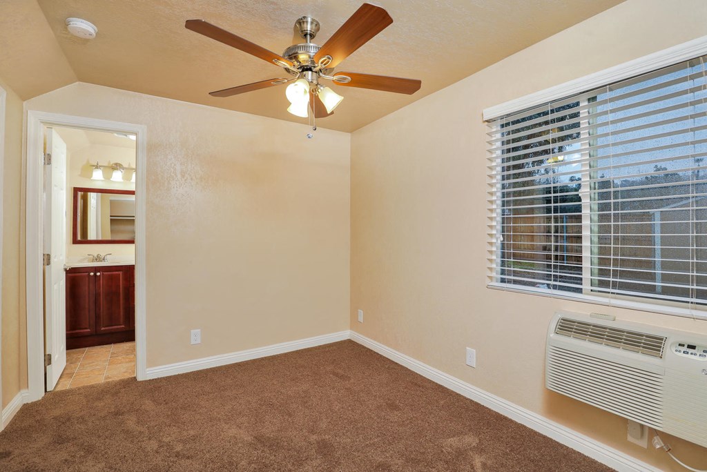 a bedroom with a ceiling fan and a window