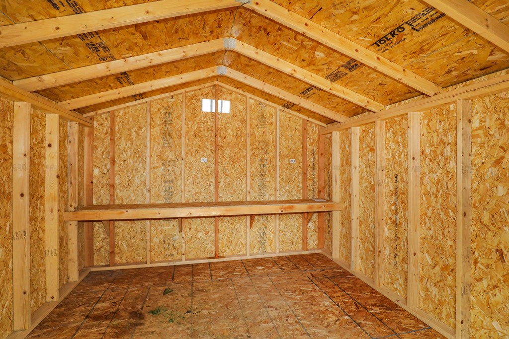 the inside of a shed with wood paneling and a window