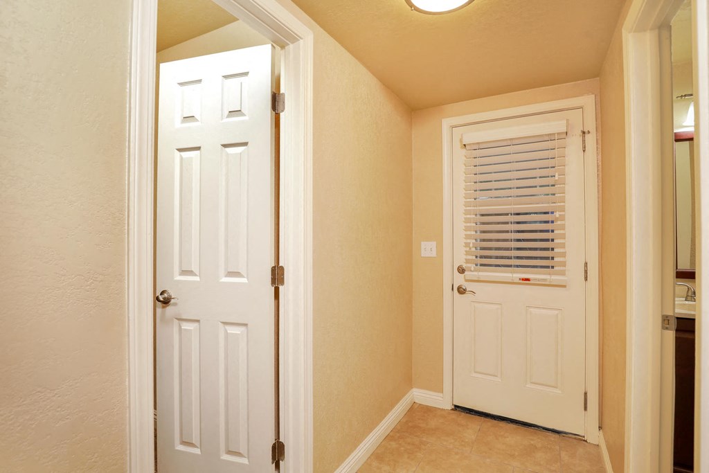 a hallway with a white door and a closet