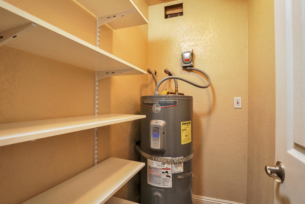 a large water heater in a room with shelves