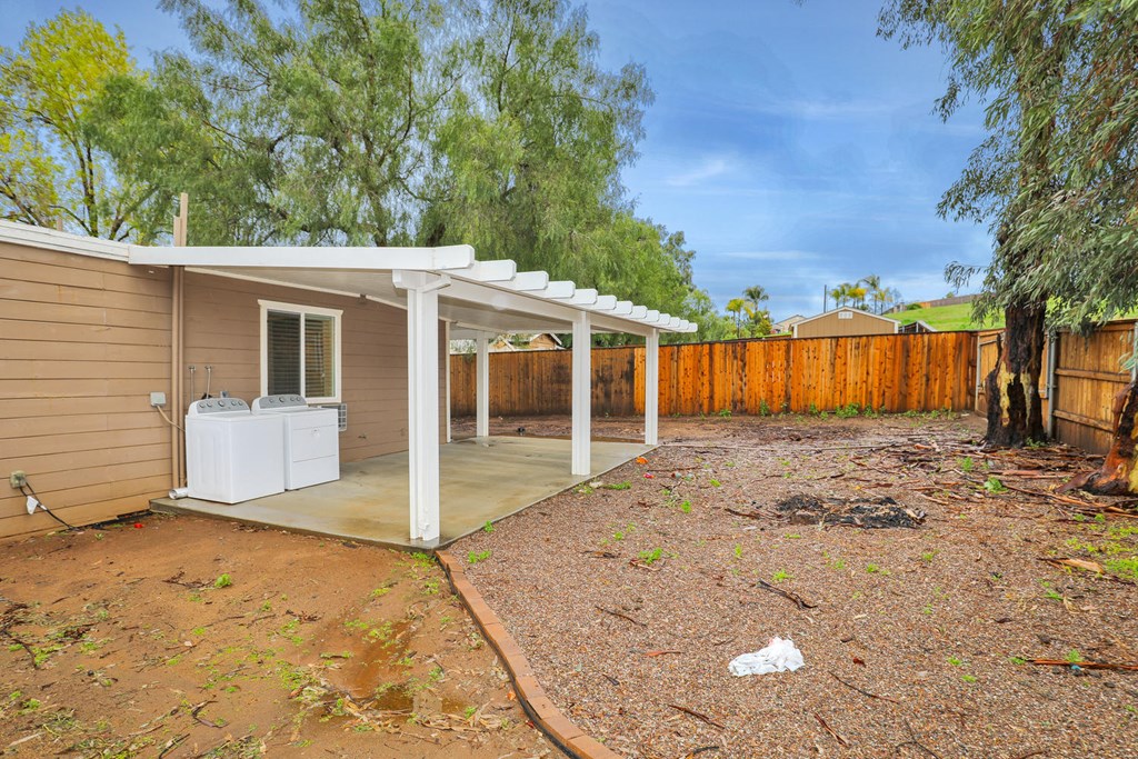 a small house with a patio and a wood fence