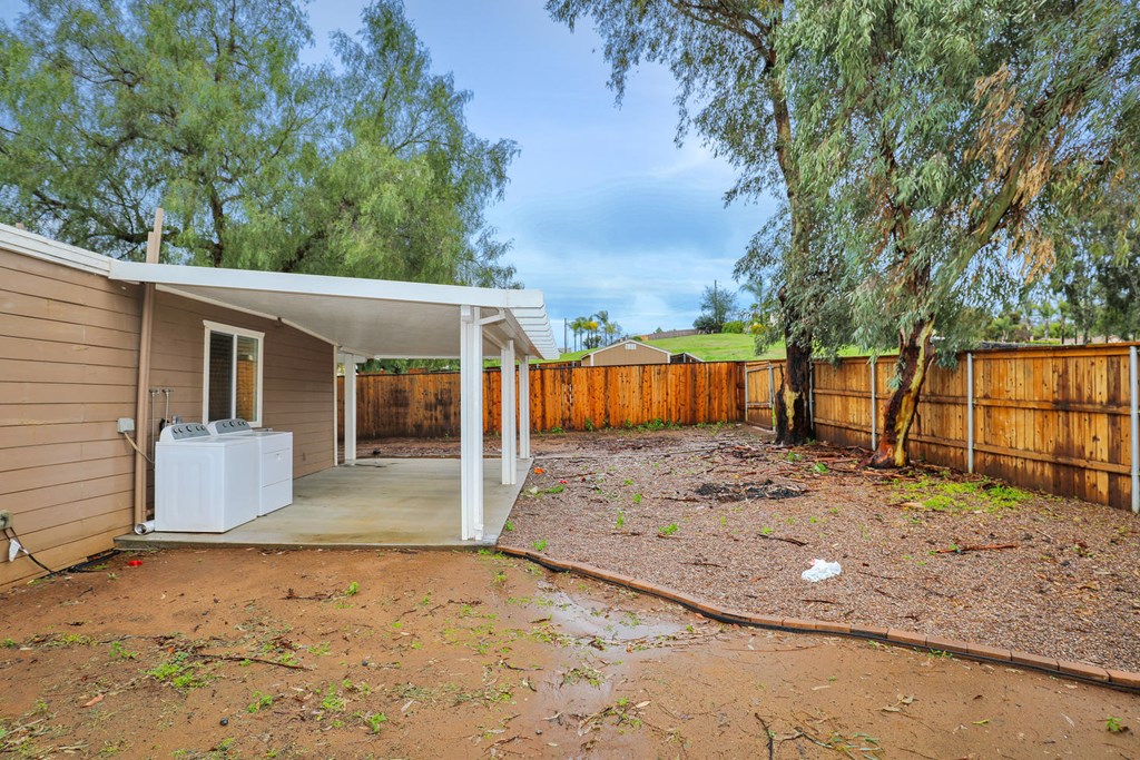 a backyard with a house and a yard with a fence