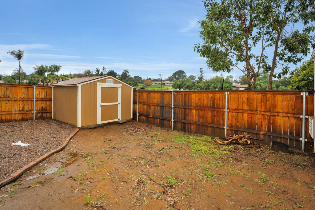 a backyard with a shed and a wooden fence