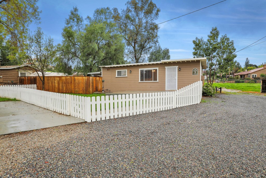 a small house with a white fence in front of it