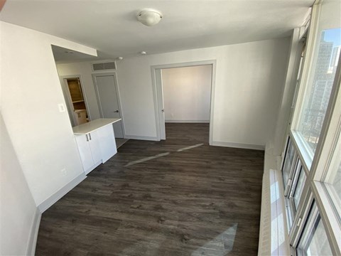 a living room with a hard wood floor and a hallway