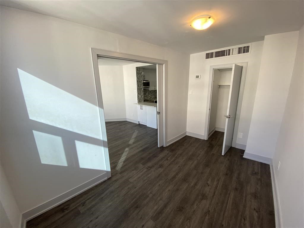 a living room and hallway with wood floors and white walls