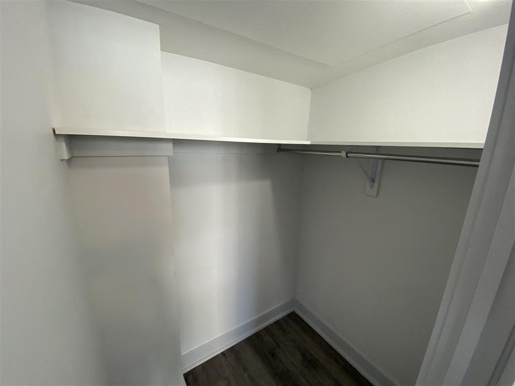 a empty room with a white wall and a closet