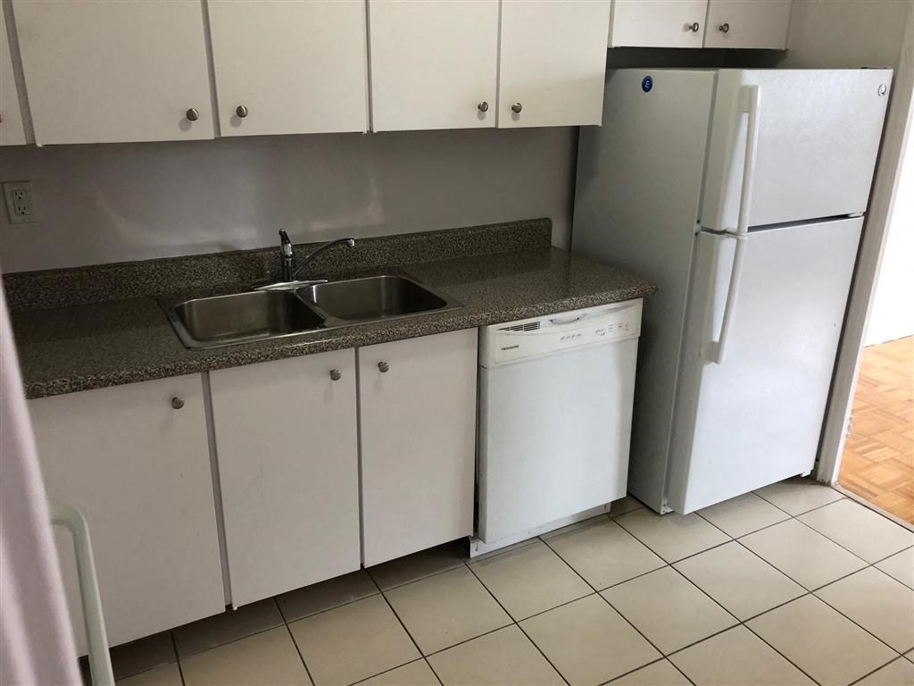 a kitchen with white cabinets and a sink and a refrigerator