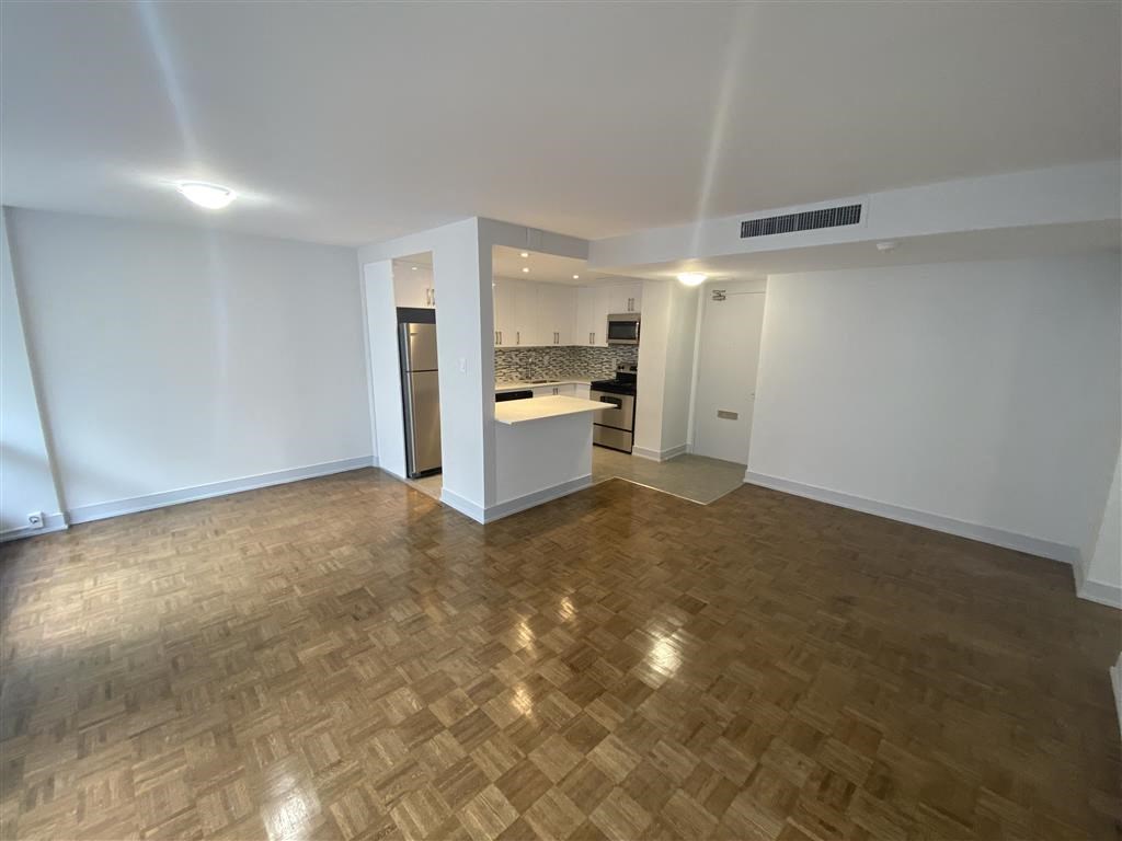 an empty living room and kitchen in an empty apartment