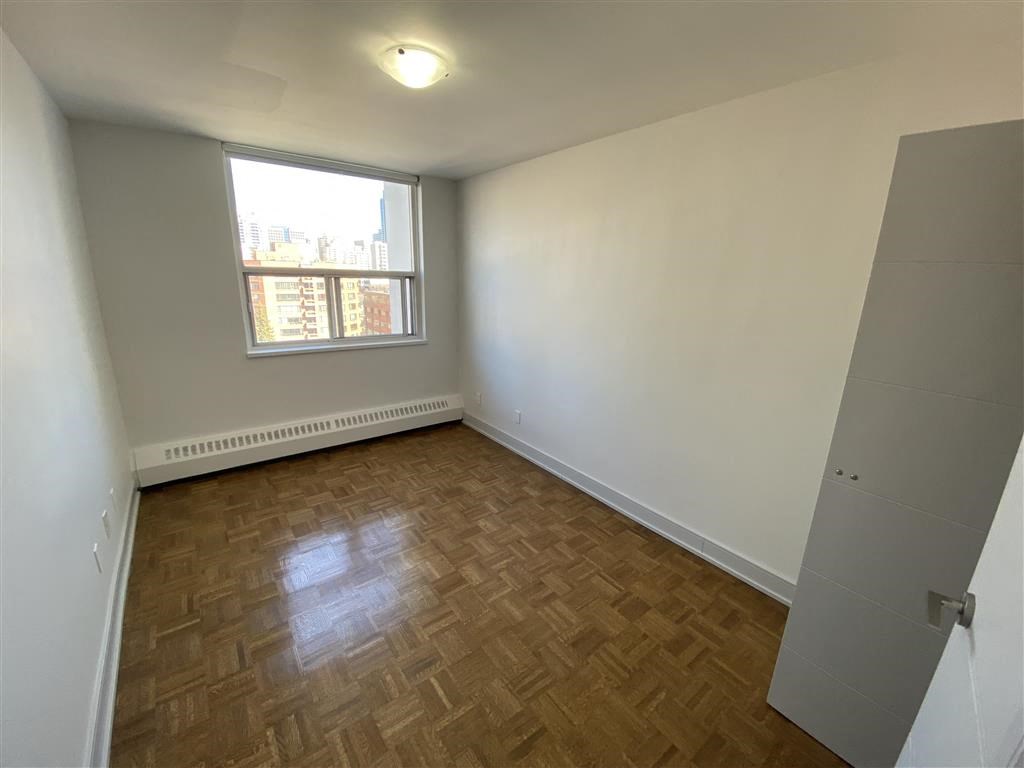 an empty room with wooden floors and a window