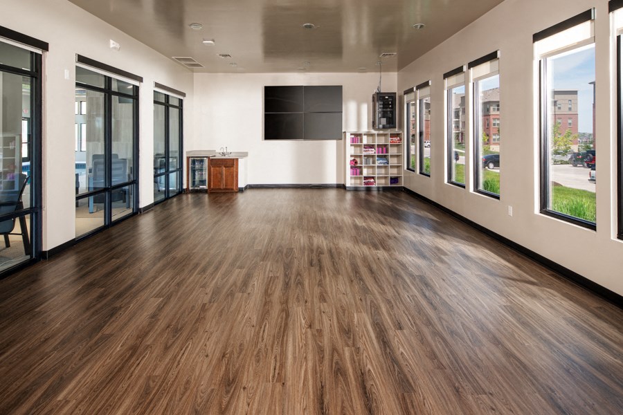 A spacious room with wooden floors and a large window.