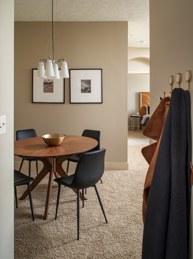 A dining room with a round table and chairs.