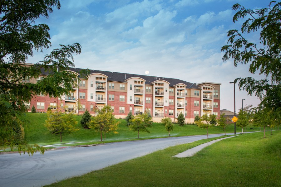 A large apartment complex with a grassy area in front.