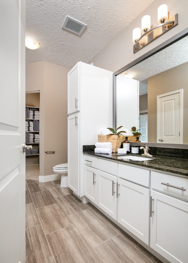 A bathroom with a white cabinet and a white toilet.