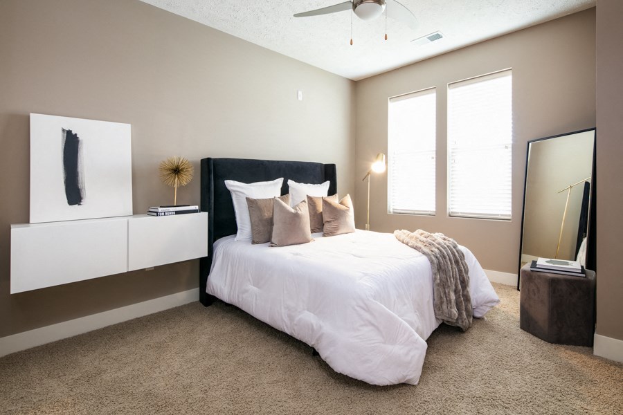 A bedroom with a large bed and a ceiling fan.