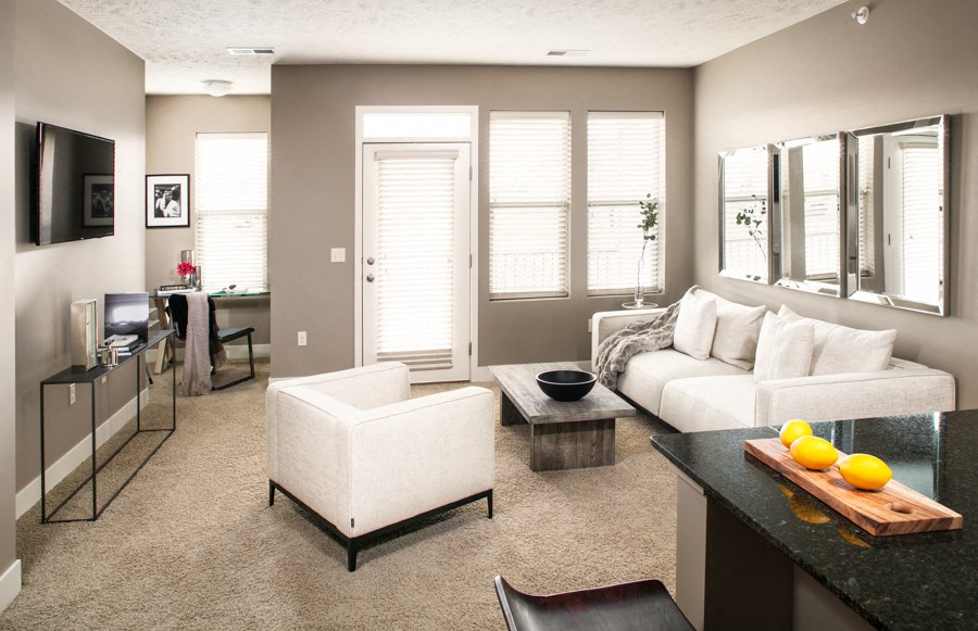 A modern living room with a white couch and a black countertop.