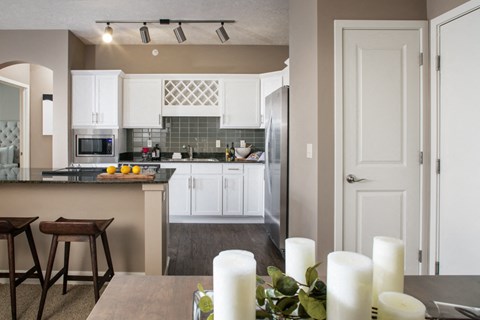 A kitchen with a counter and bar stools.