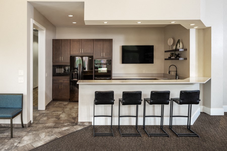 A modern kitchen with a bar area and a television.