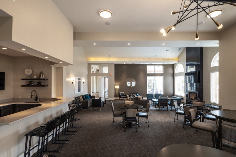 A large room with tables and chairs and a bar area.