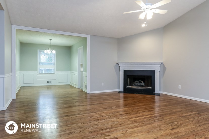 the living room with wood flooring and a fireplace