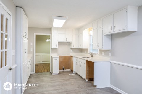 a large white kitchen with white cabinets and a white counter top