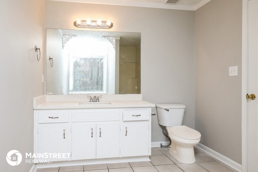a bathroom with a sink toilet and a mirror
