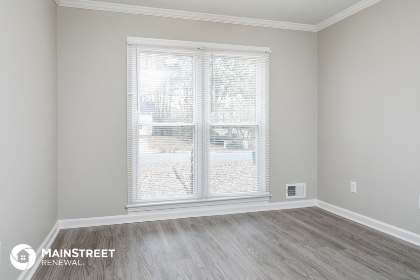 the interior of a room with wooden floors and a large window