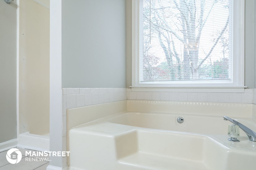 a bathroom with a white sink and a window