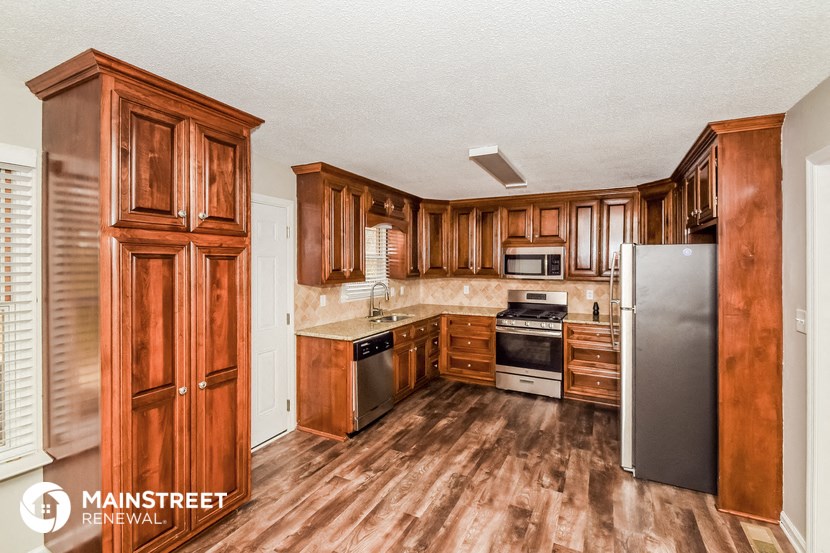 a kitchen with wooden cabinets and stainless steel appliances