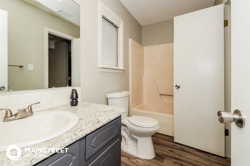 a bathroom with a toilet and a sink and a mirror