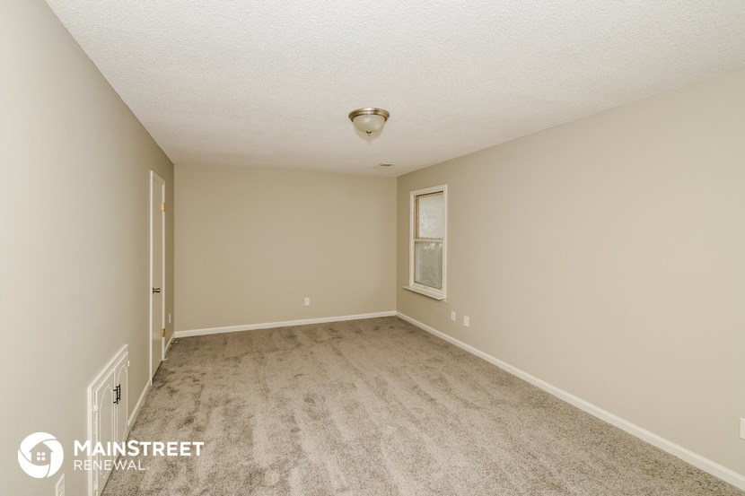 a spacious living room with a carpeted floor and a window