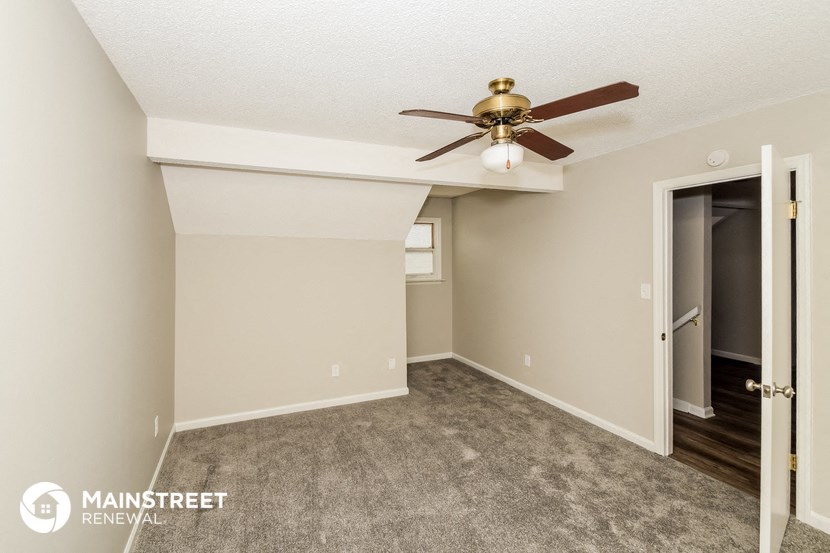 a bedroom with a ceiling fan and a door to a closet