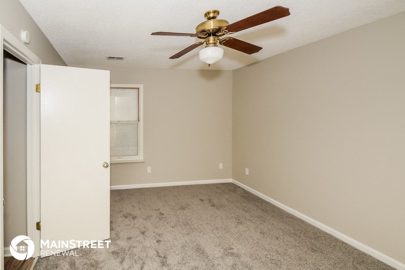 a bedroom with carpet and a ceiling fan