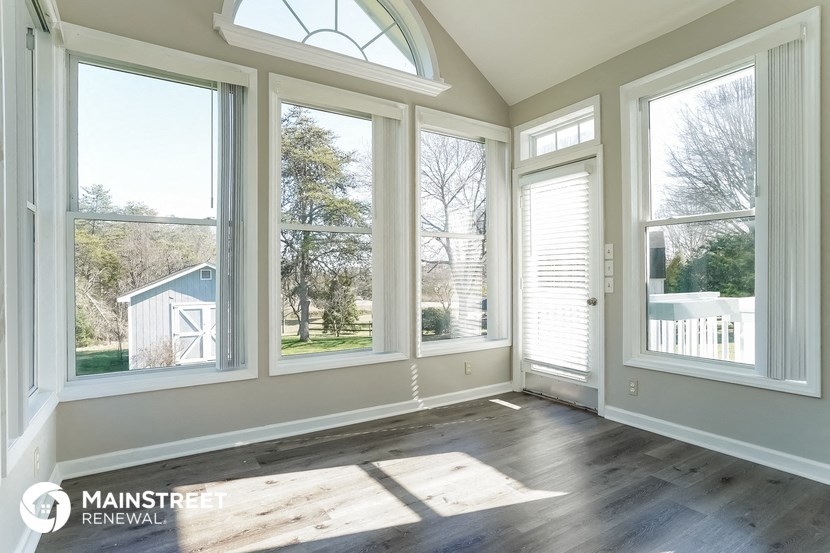 a living room with large windows and a wooden floor