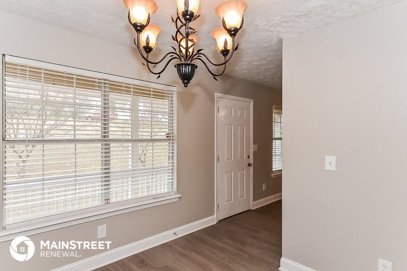 the living room of a house with a large window and a white door