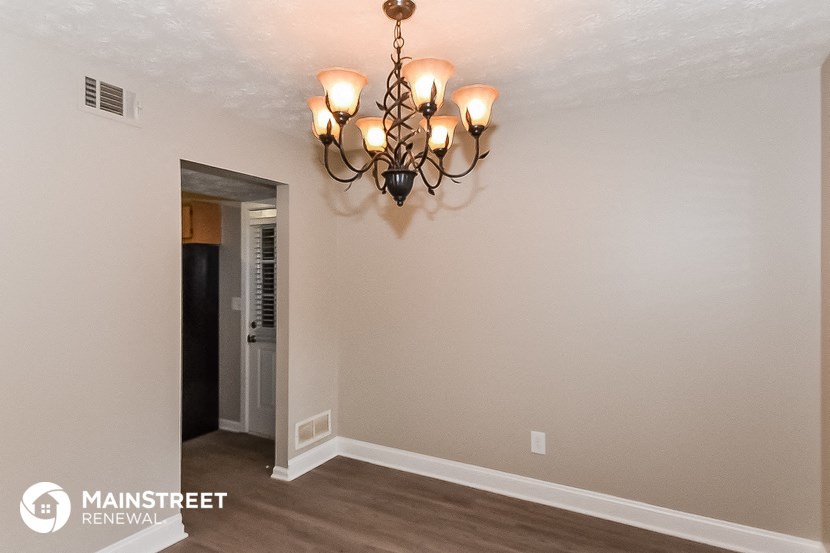 the living room of a renovated house with a chandelier