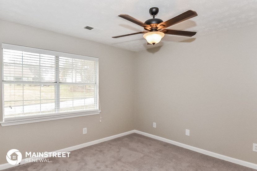 a bedroom with a ceiling fan and a window