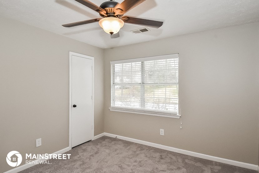the master bedroom has a ceiling fan and a window