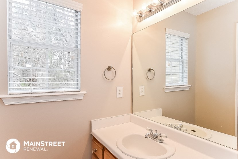 a bathroom with a sink and a mirror and a window